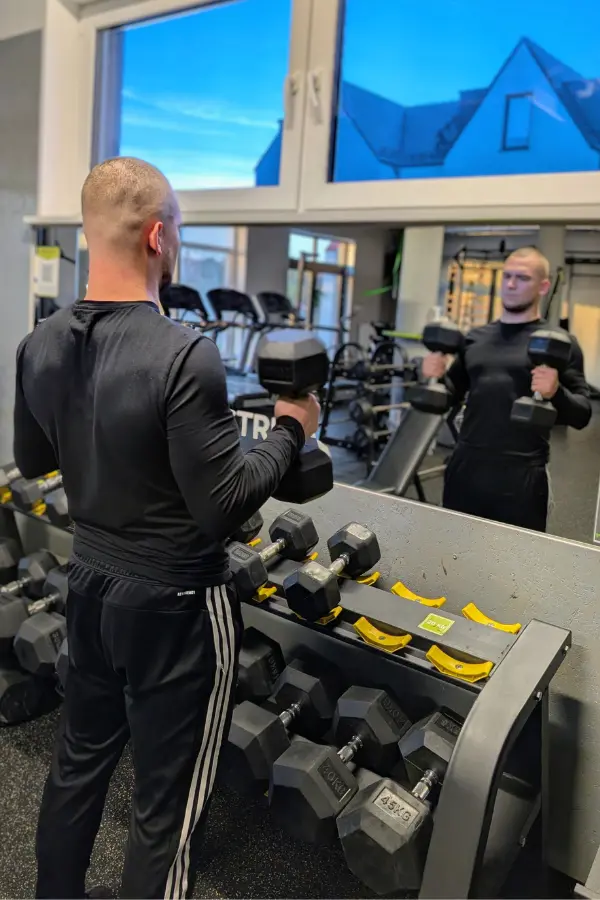 Marcel Gielezy trenuje biceps hantlami