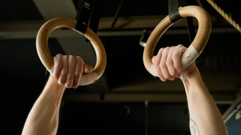 Atleta trenuje na kółkach gimnastycznych