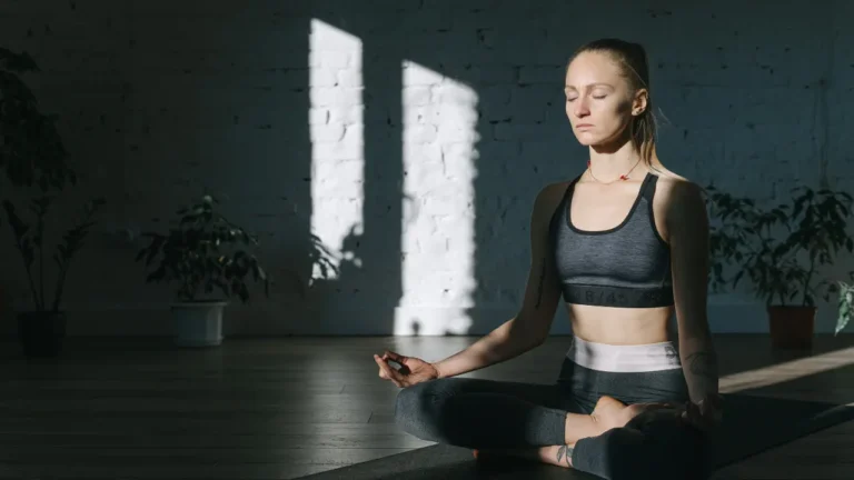 Kobieta w pozycji medytacyjnej praktykuje relaksujące techniki oddechowe