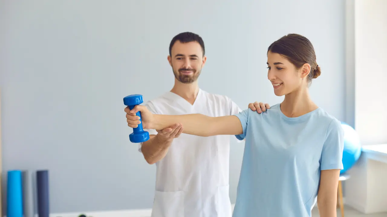 Trener medyczny podczas treningu rehabilitacyjnego z pacjentką