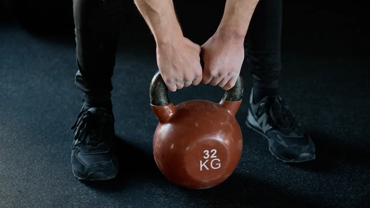 Zawodnik sportów walki przygotowuje się do podniesienia odważnika kulowego (kettlebell)